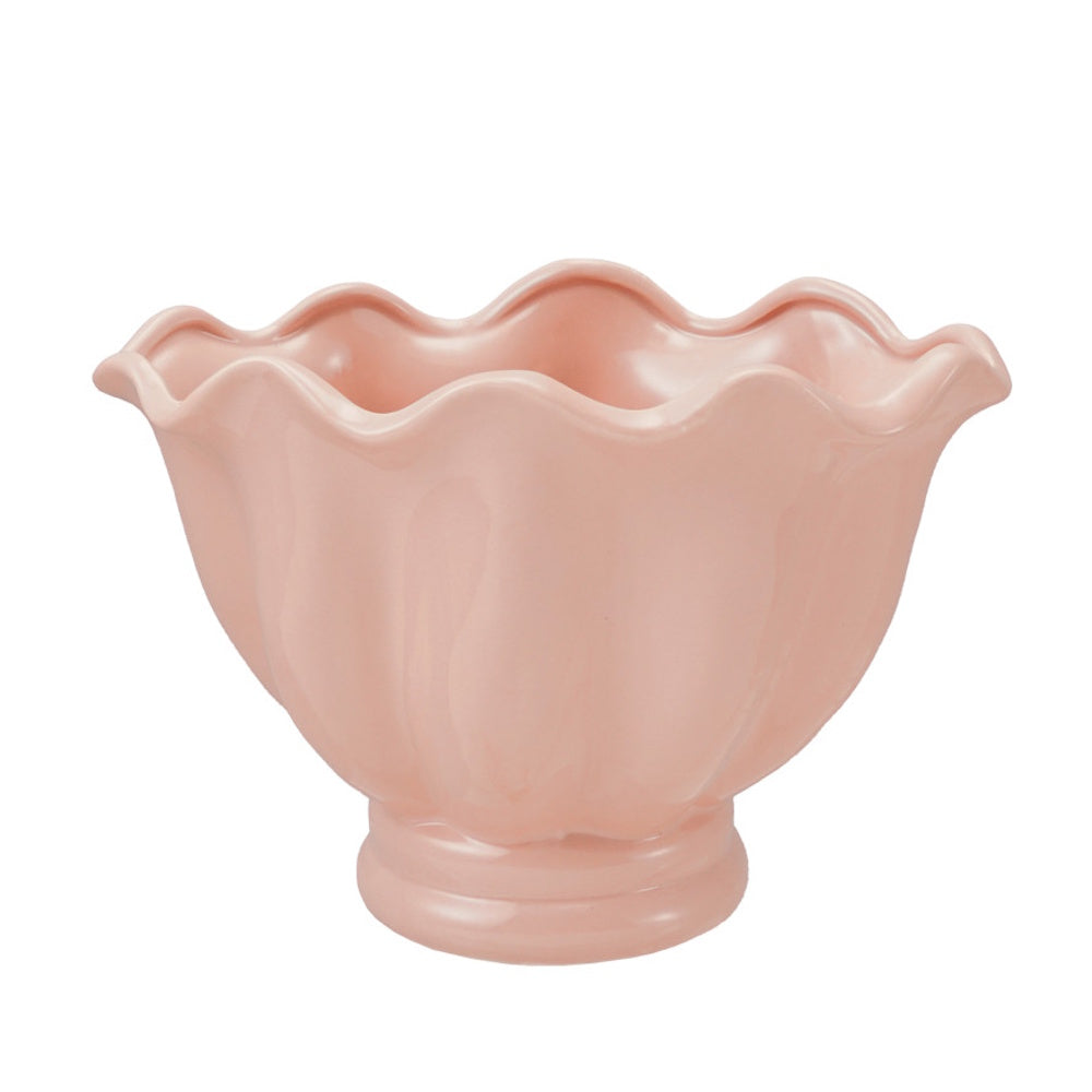 Pink ceramic footed bowl with a ruffled, scalloped rim against a white background.