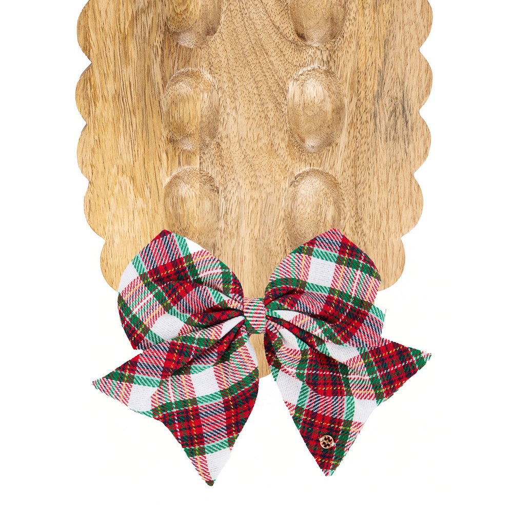 Red and green plaid bow attached to a scalloped wooden tray.
