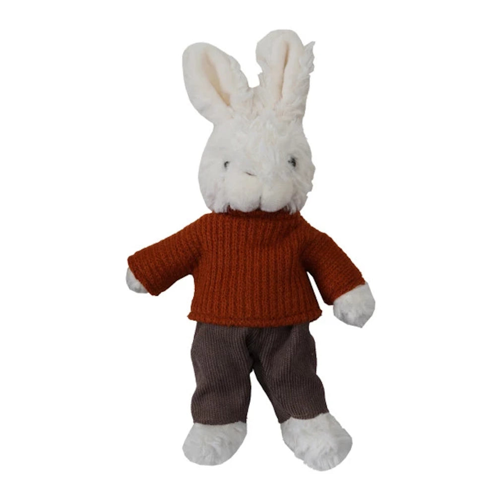 White plush bunny toy wearing a burnt orange ribbed sweater and brown trousers on a white background.