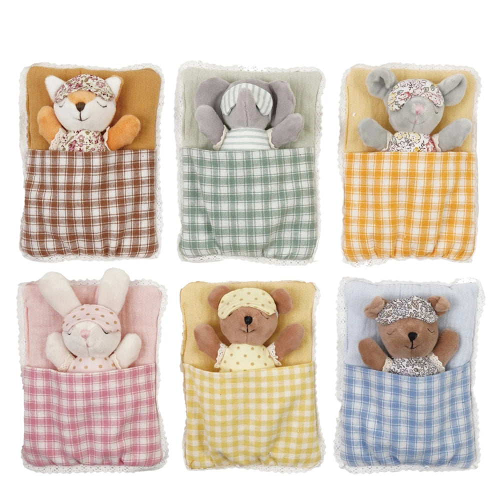 Set of six small plush animals wearing eye masks, sleeping in colorful plaid sleeping bags with lace trim.