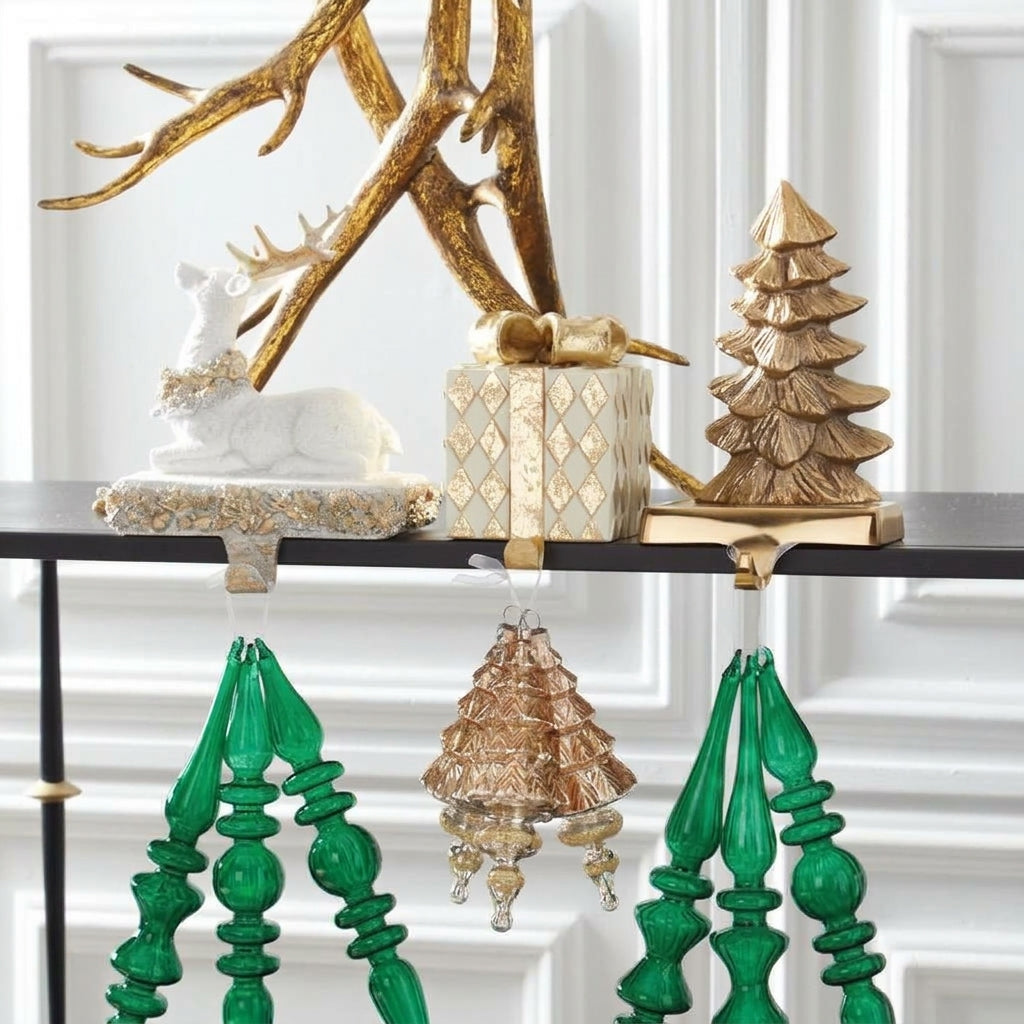 Lifestyle display showing the polished brass Christmas tree stocking holder holding green ornaments, alongside other holiday decor.