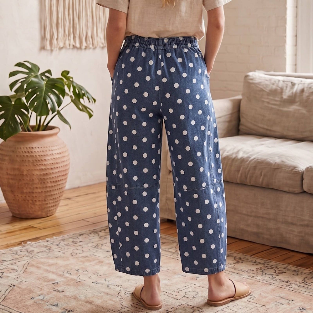 Back view of a person wearing blue denim barrel-leg pants with a white polka dot pattern.
