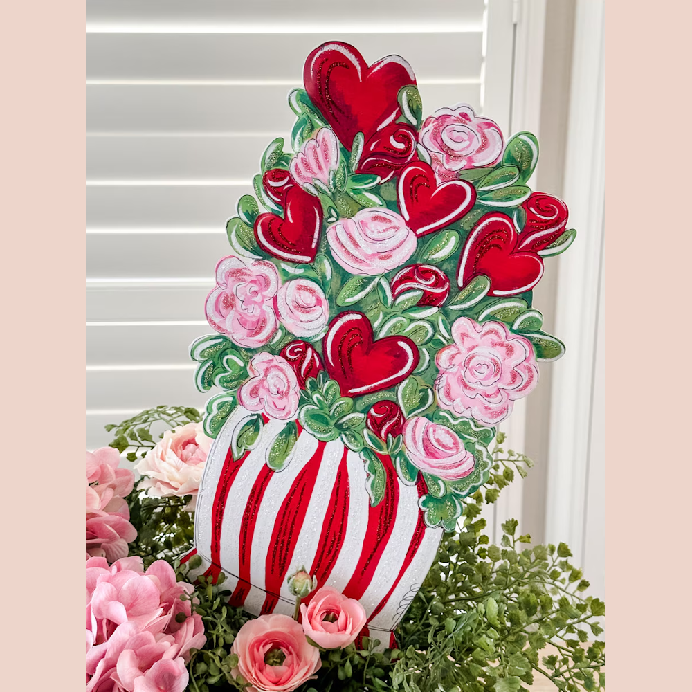 Hand-painted Valentine's Day decor featuring red hearts and pink roses in a red and white striped planter with glitter.