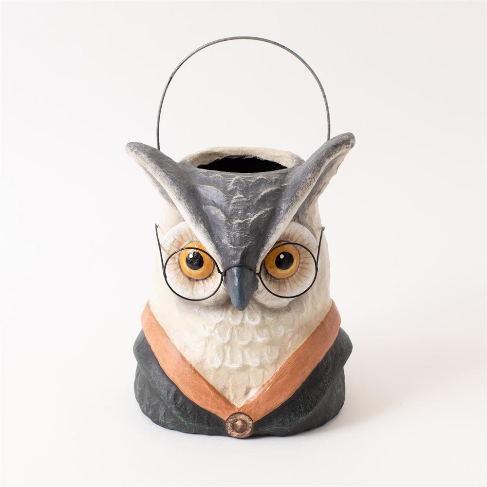 A paper-mâché owl bucket wearing round wire glasses and a dark robe, with a wire handle.