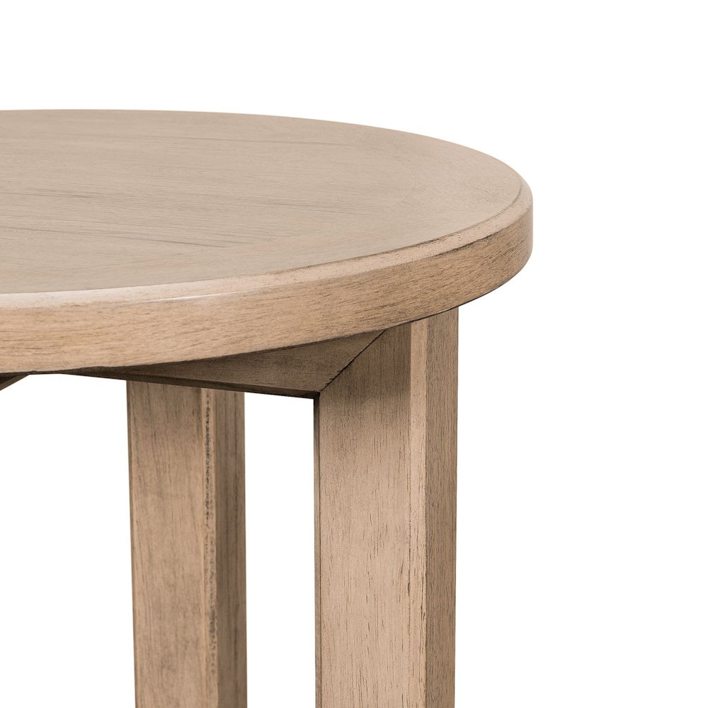 Close-up of a Proximity Place light wood round chairside table showing its smooth top and modern legs.
