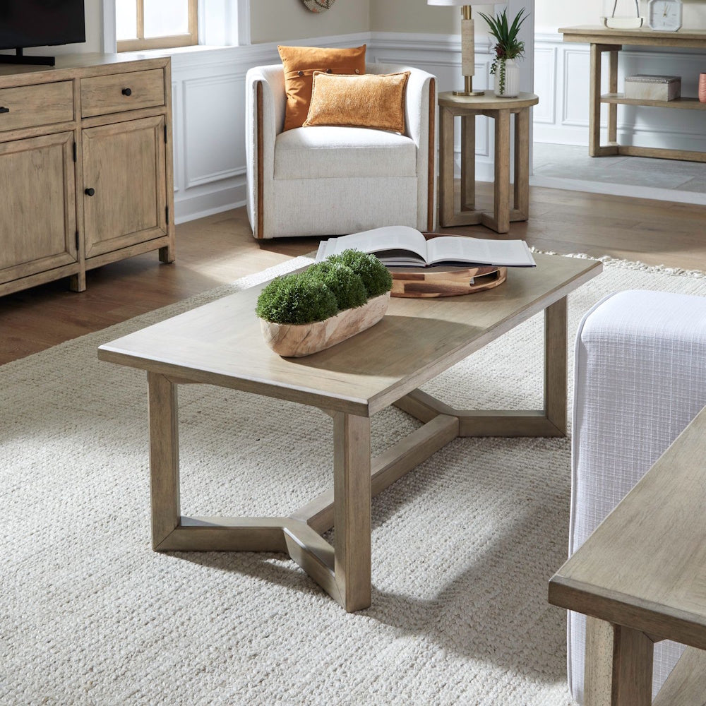 Proximity Place rectangular wooden cocktail table on a textured rug in a modern living room.