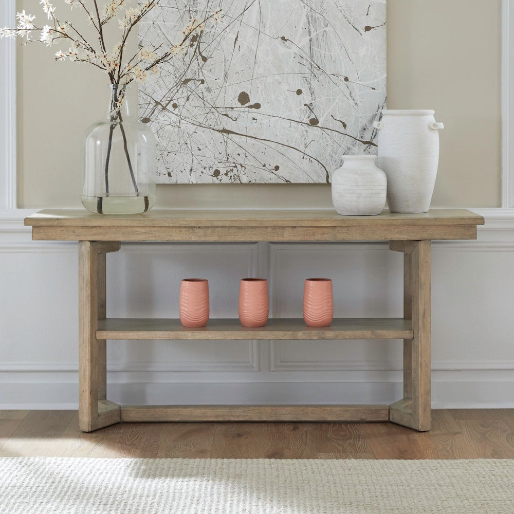 Proximity Place light wood console sofa table styled with vases and modern artwork.