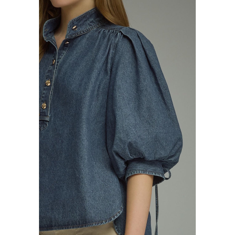 Close-up front view of a dark blue denim top showcasing button placket and pleated puff sleeve.