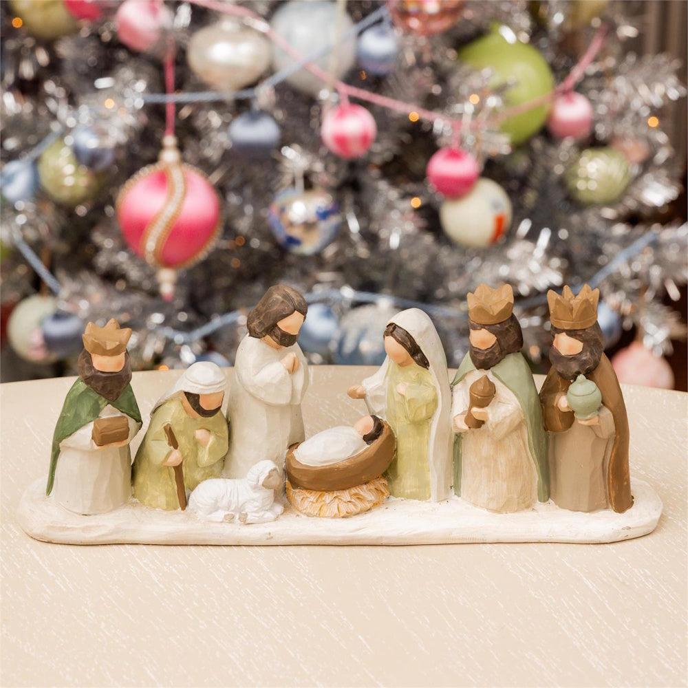 Carved nativity scene set with Mary, Joseph, baby Jesus, and Wise Men on display.
