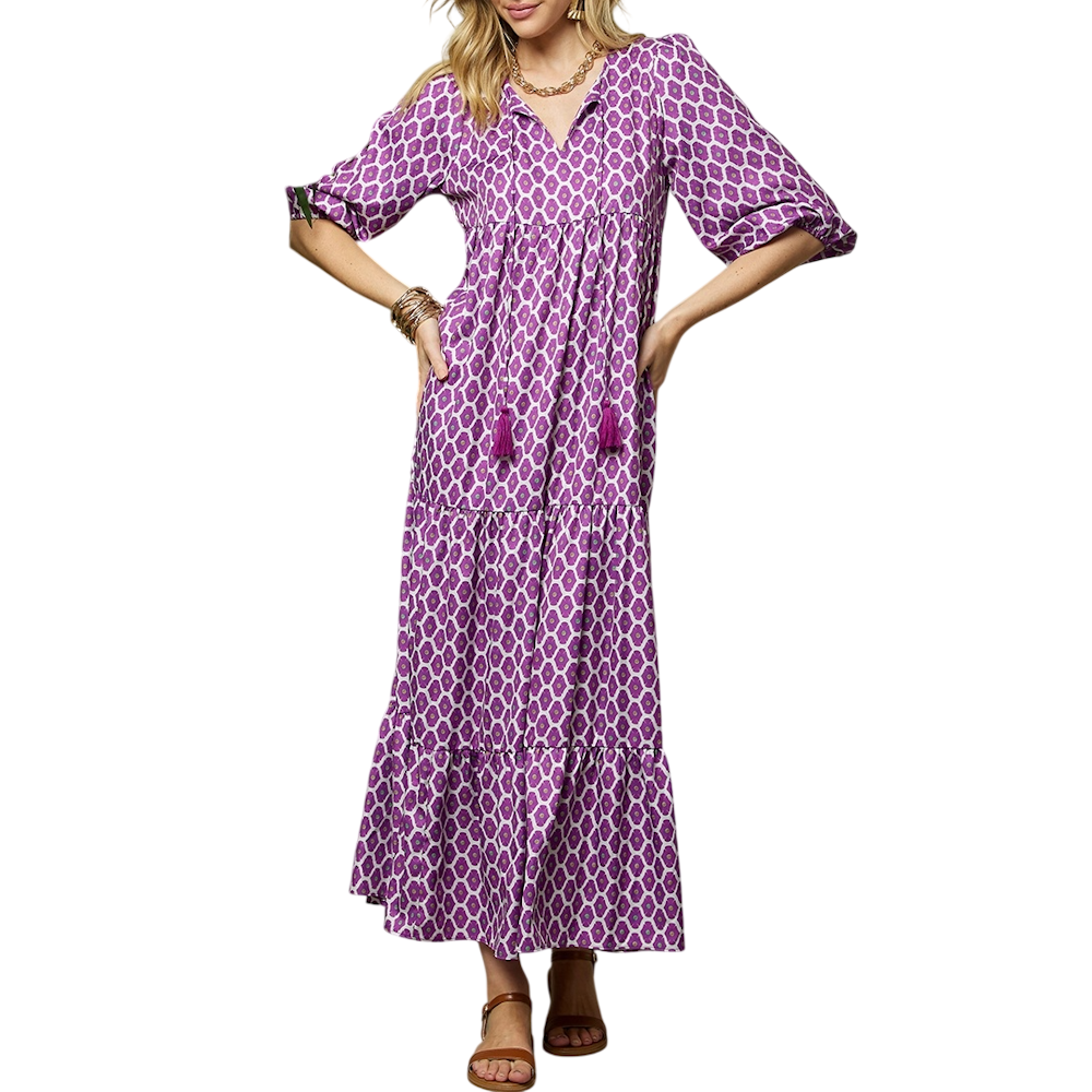 A woman models a purple and white geometric print maxi dress with three-quarter puff sleeves and a tiered skirt.