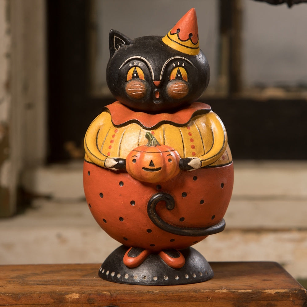 Vintage Halloween black cat figurine wearing a colorful costume and holding a small jack-o'-lantern.