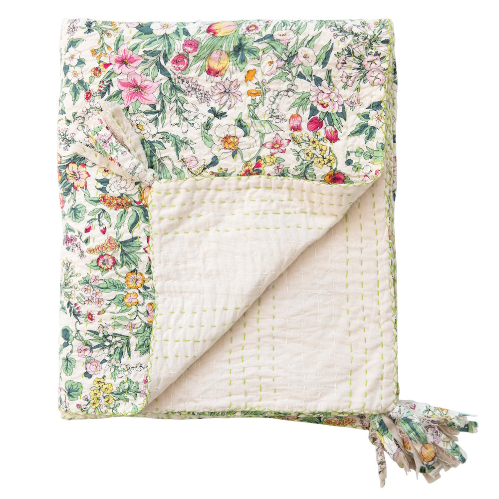 Quilted cotton floral throw blanket with green kantha stitching and decorative tassels on a white background.