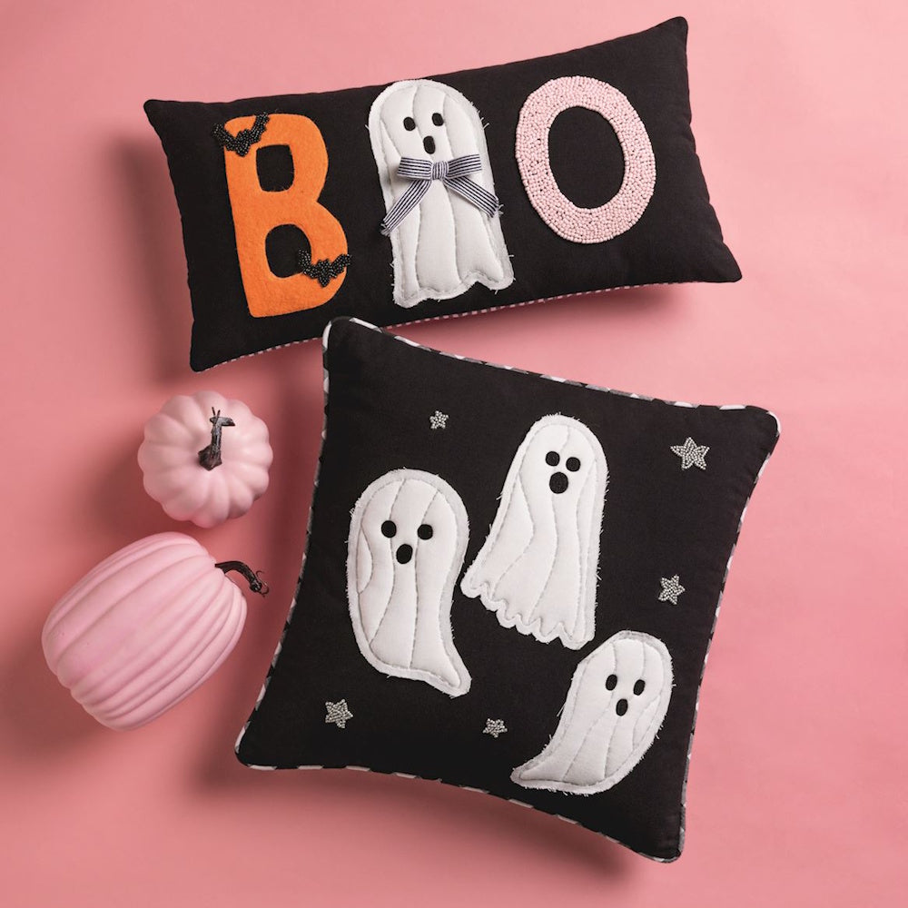 Two black Halloween throw pillows featuring quilted ghosts and "BOO" text on a pink background.