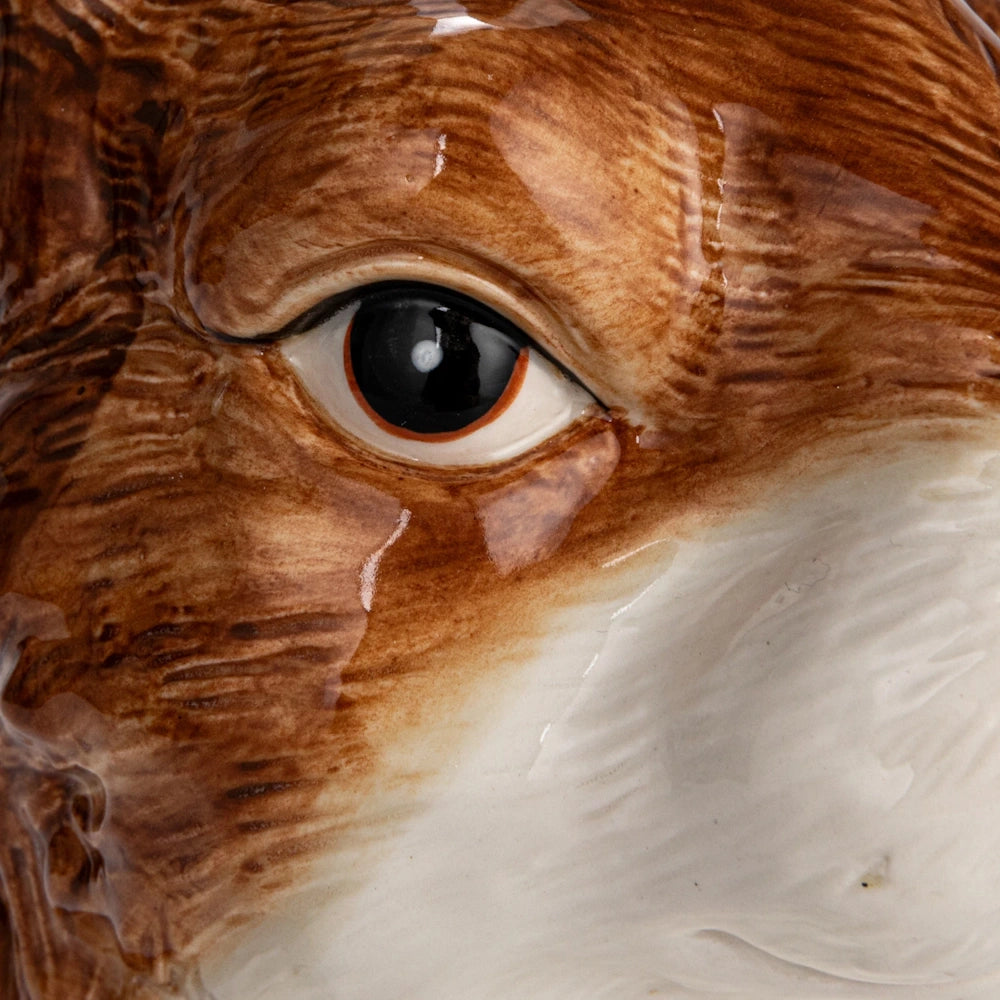 Close-up of a hand-painted stoneware vase featuring a detailed, glazed brown and white animal eye.