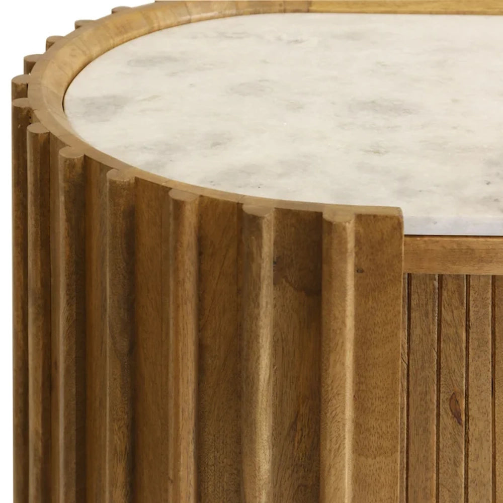 Close-up of a fluted wood cabinet featuring a white marble top, highlighting the natural grain and textured tambour design.