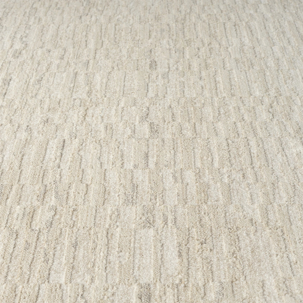 Close up of cream area rug with soft textured pile and subtle geometric pattern in neutral modern style.