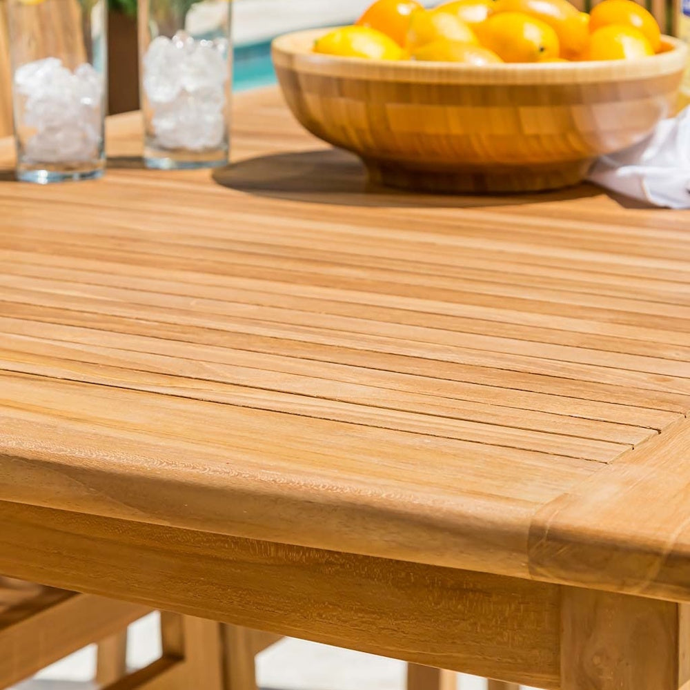 Close-up view of a slatted teak outdoor tabletop with a lemon bowl and iced drinks.