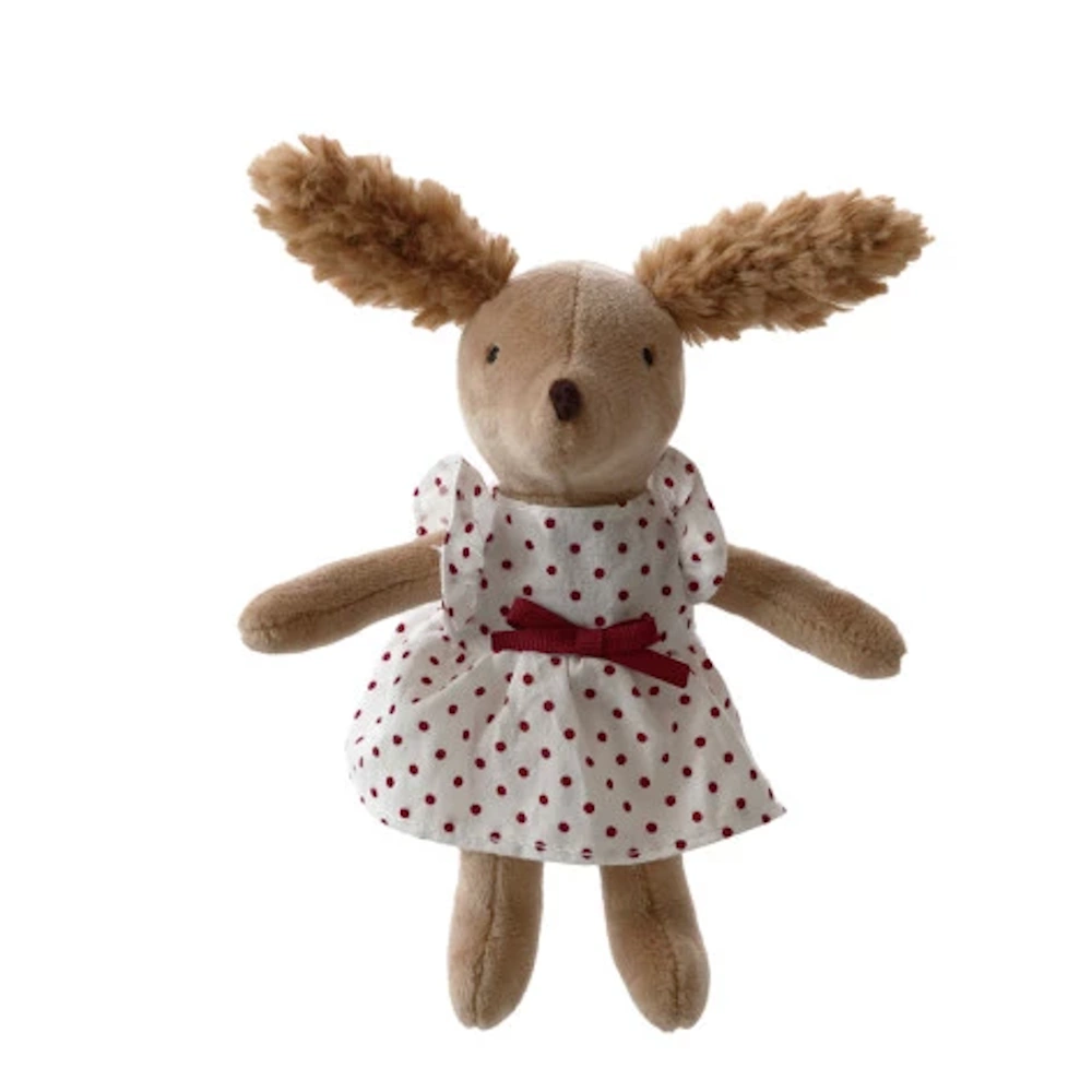 Plush tan dog doll with fuzzy ears wearing a white cotton dress with red polka dots and a bow. Isolated on white.