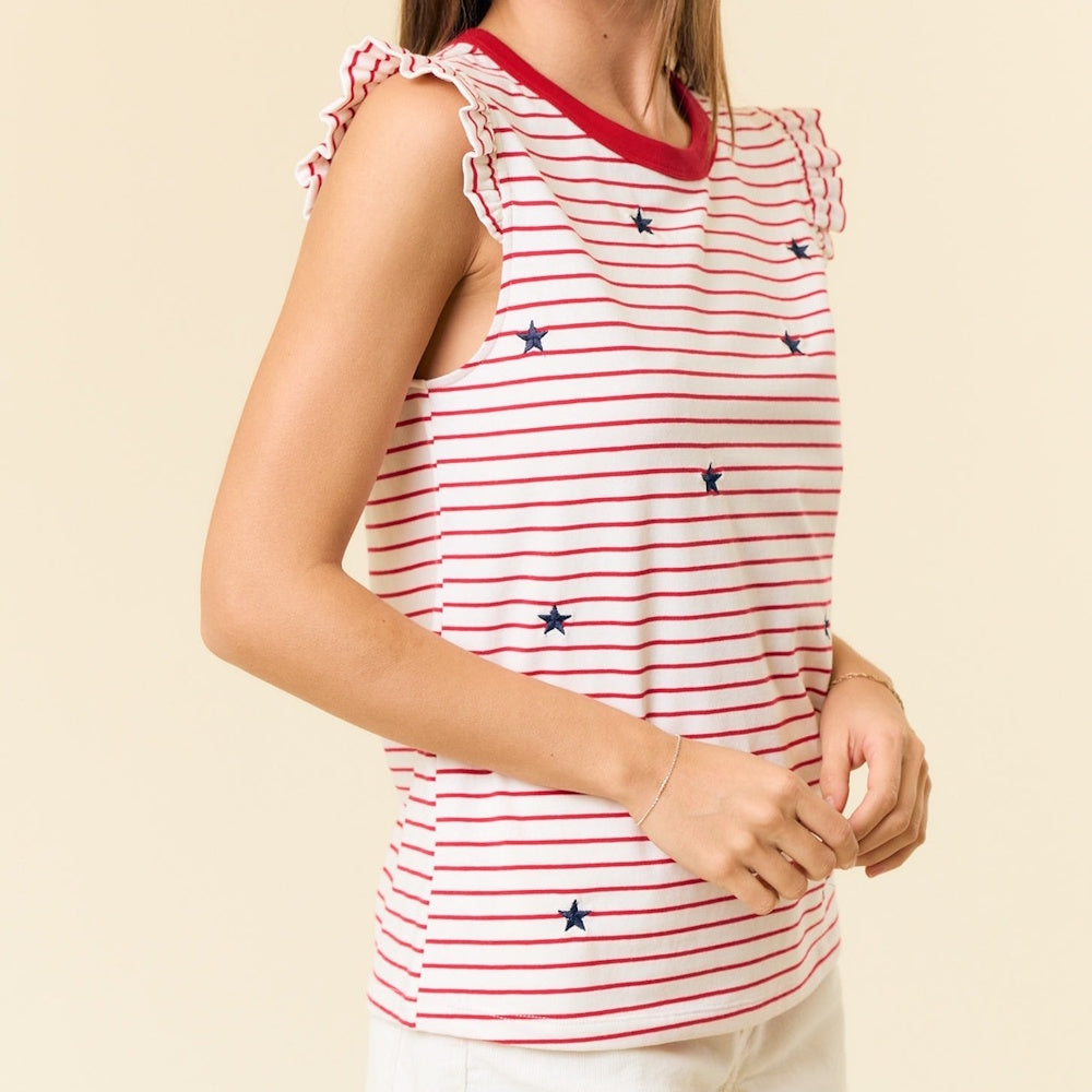 Woman in a striped top with red ruffles at the shoulders and scattered blue stars, shown from the side.