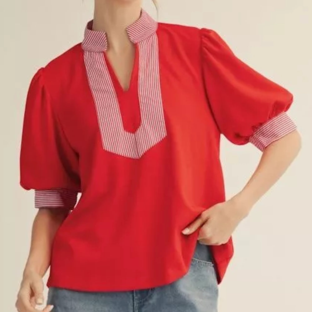 Red short-sleeve blouse with a striped V-neck collar and puff sleeves, paired with blue jeans.