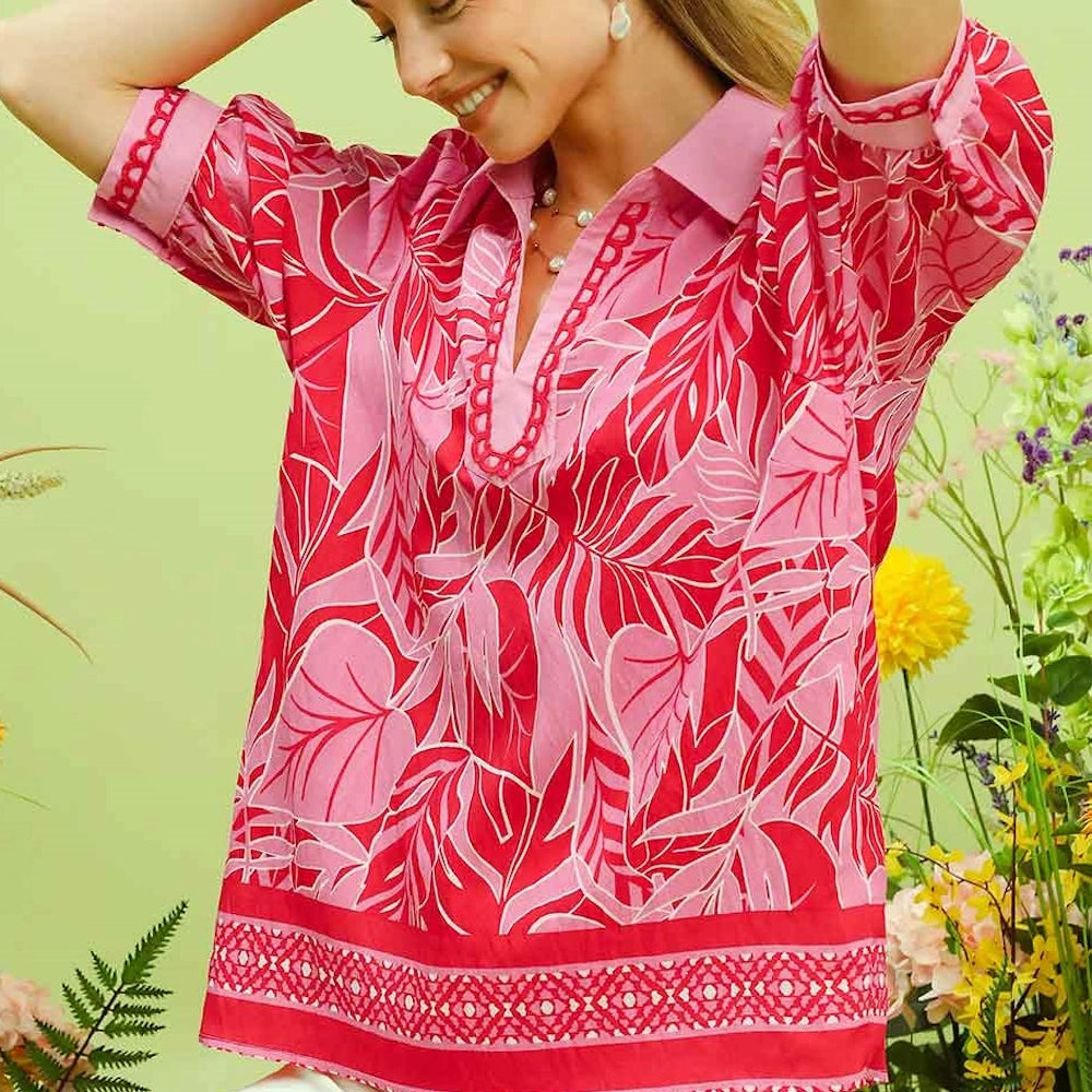 Red and pink tropical leaf print puff sleeve blouse with a collared V-neckline and decorative border hem.