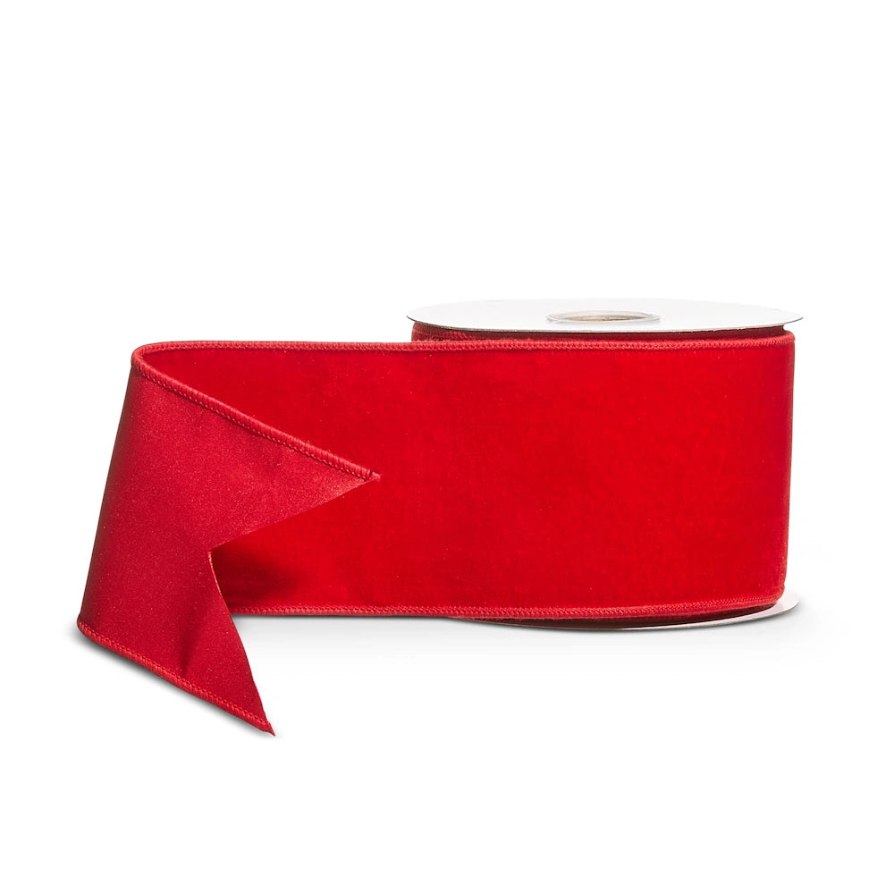 Roll of vibrant red velvet wired Christmas ribbon with a cut end.