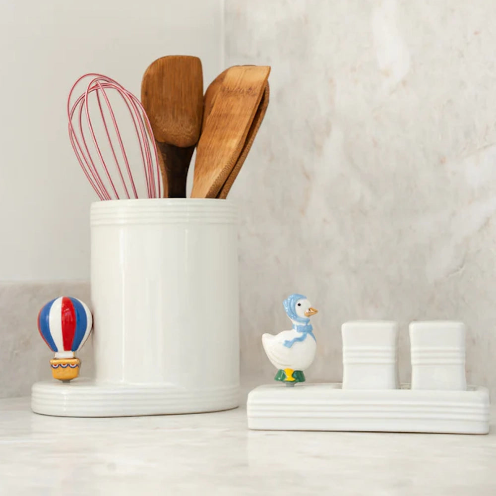 White ceramic utensil holder with hot air balloon detail, paired with a duck-themed salt and pepper shaker set.