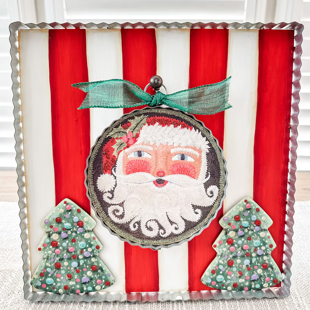 Front view of the red and white display board styled with a Santa ornament and two tree cutouts.