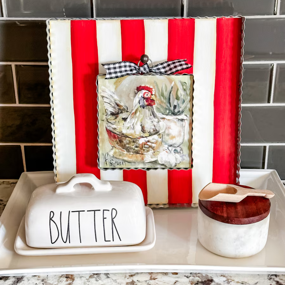 Front view of the red and white display board styled with a chicken painting and a buffalo check bow.