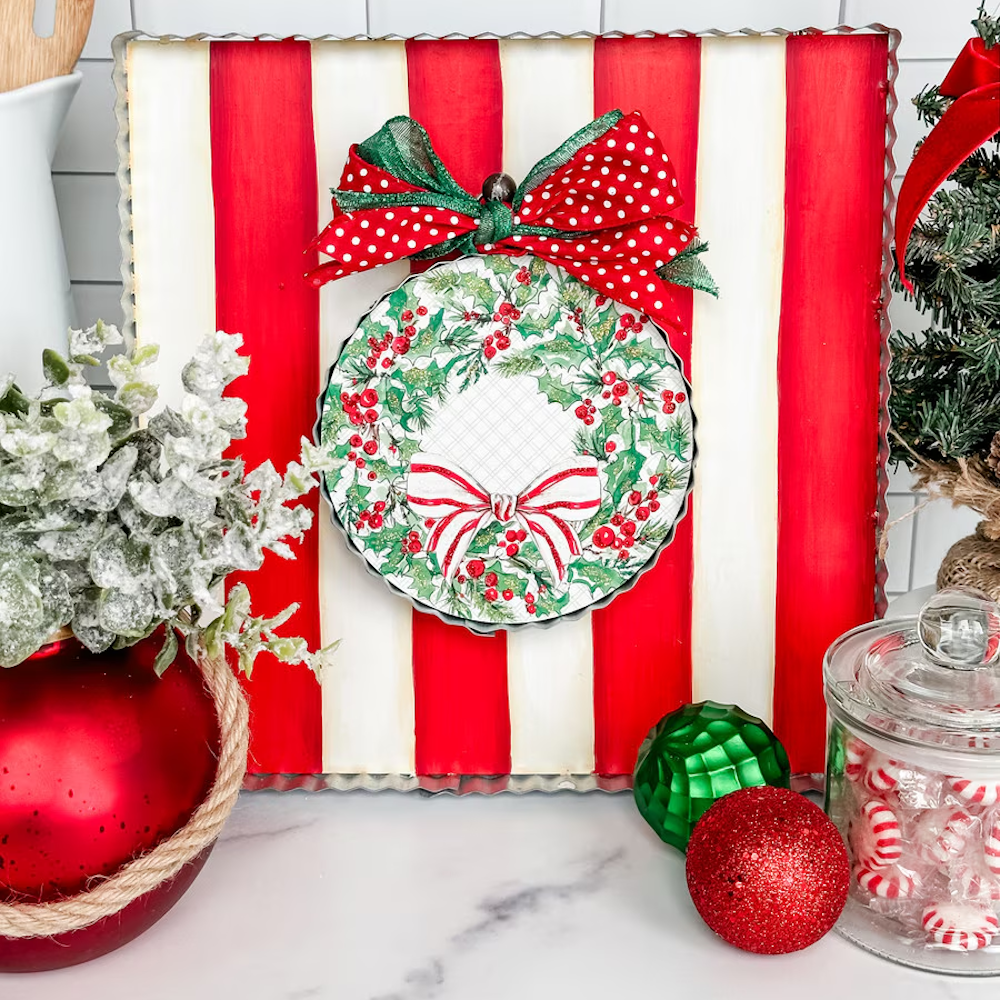 Front view of the red and white display board styled with a holiday wreath ornament and polka dot bow.