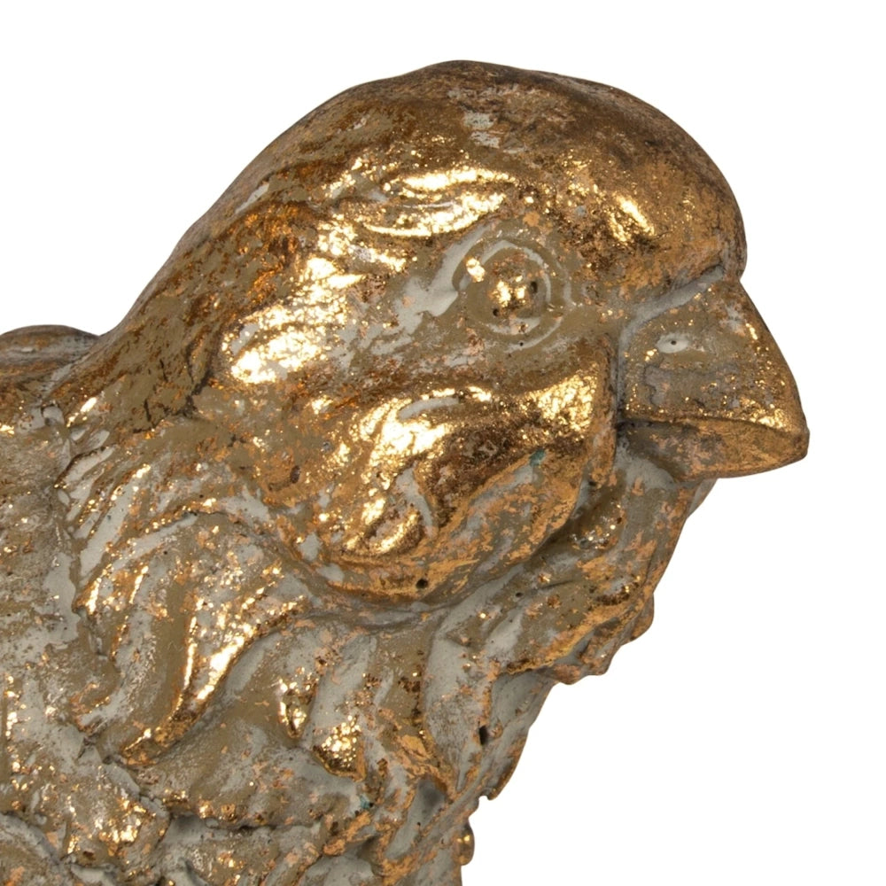 Close-up of a gold bird-shaped resin candle holder with a distressed, vintage metallic finish.
