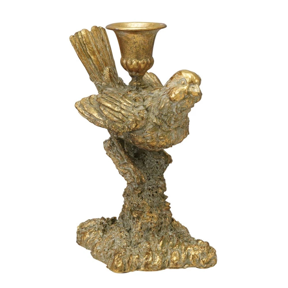 Gold resin bird-shaped taper candle holder with antique finish, perched on a textured base on white background.