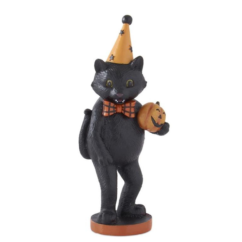 A vintage-style black cat figurine wearing a pointy party hat and bowtie, holding a small jack-o'-lantern.