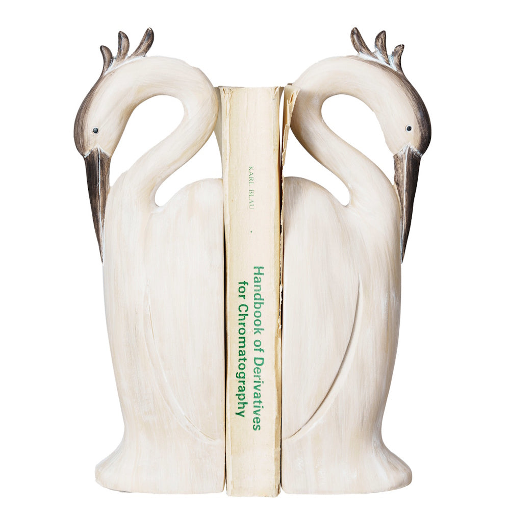 Resin heron-shaped bookends with a faux wood finish holding a book on a white background.