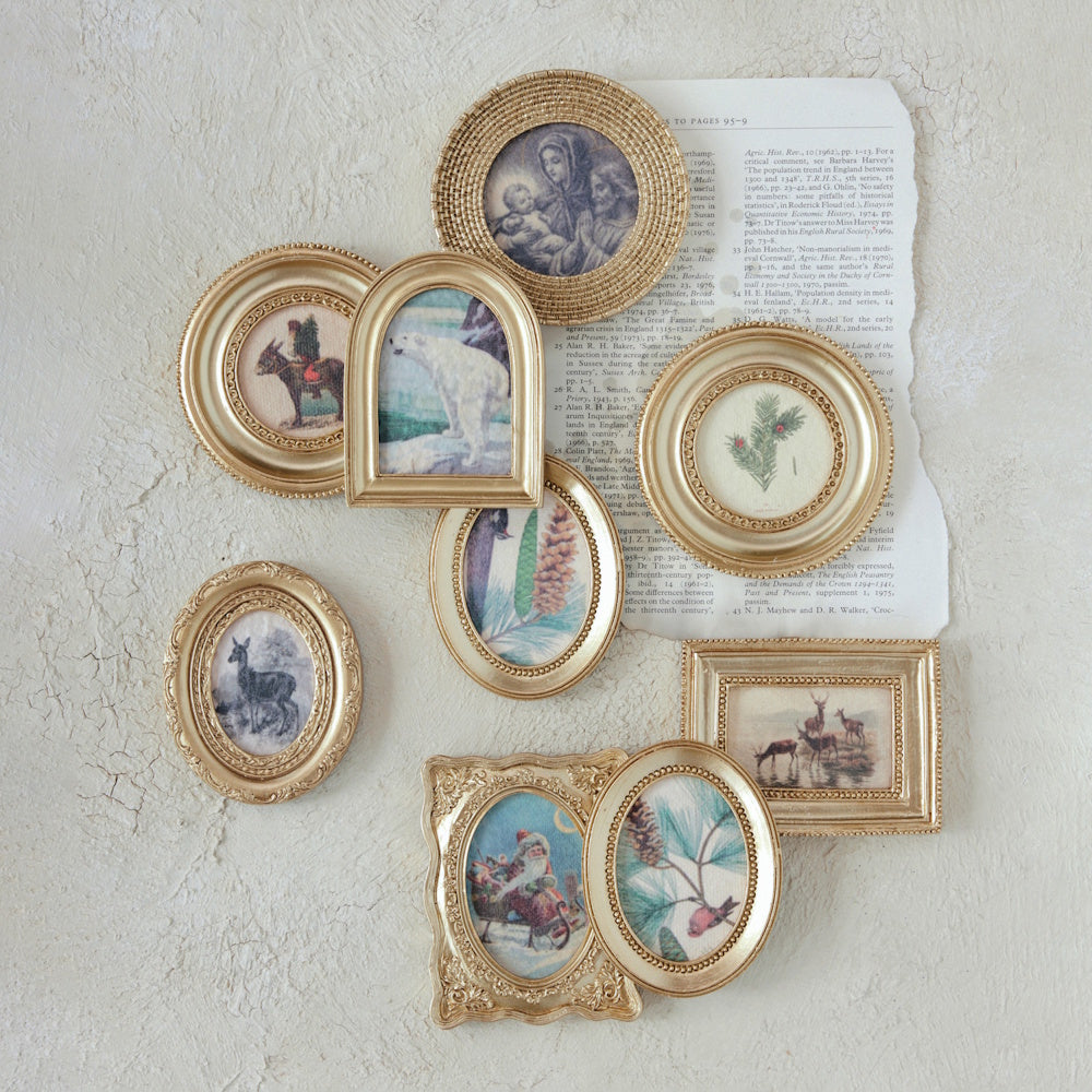Collection of small gold-framed vintage art featuring seasonal scenes and animals, artfully arranged.