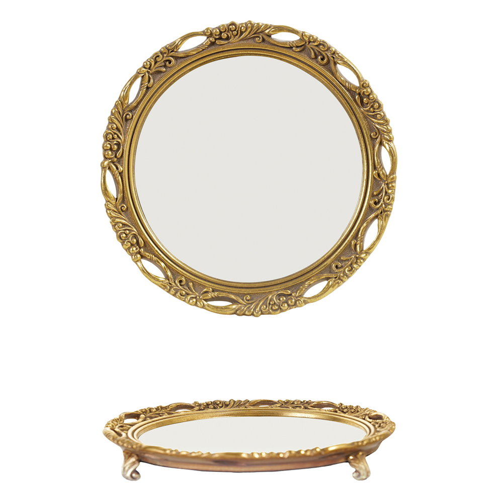 Ornate round vintage gold mirrored tray featuring an intricate carved frame and footed stand.