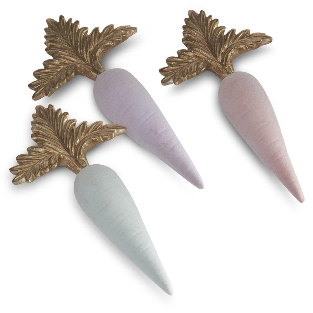 Three decorative pastel carrots in purple, pink, and mint green with ornate gold-colored leaves.