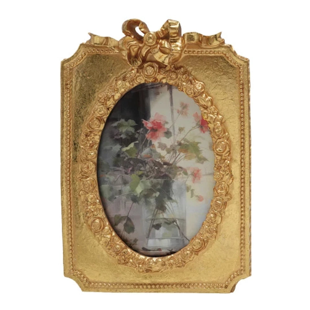 Vintage gold resin photo frame with floral art, featuring an ornate oval border and decorative bow on top.