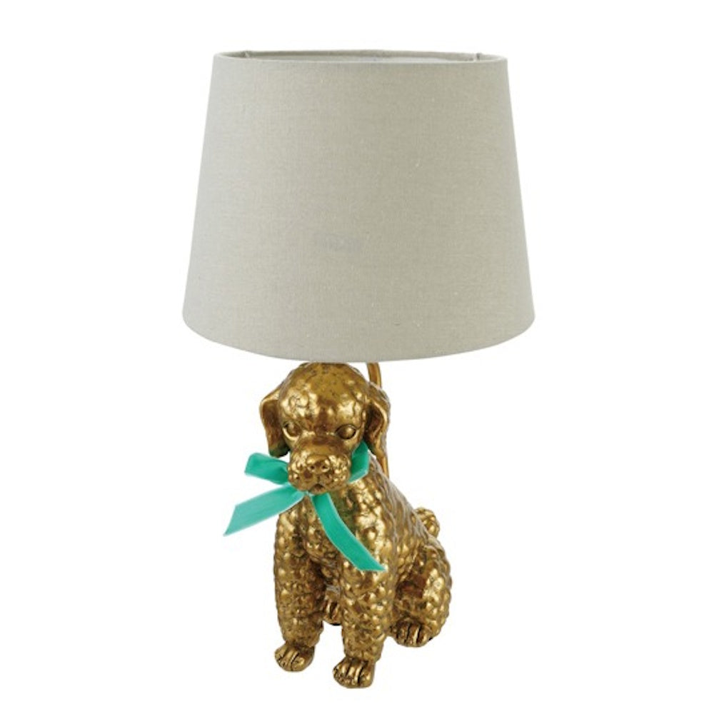 Gold poodle-shaped table lamp with a teal ribbon bow and a neutral fabric drum shade against a white background.