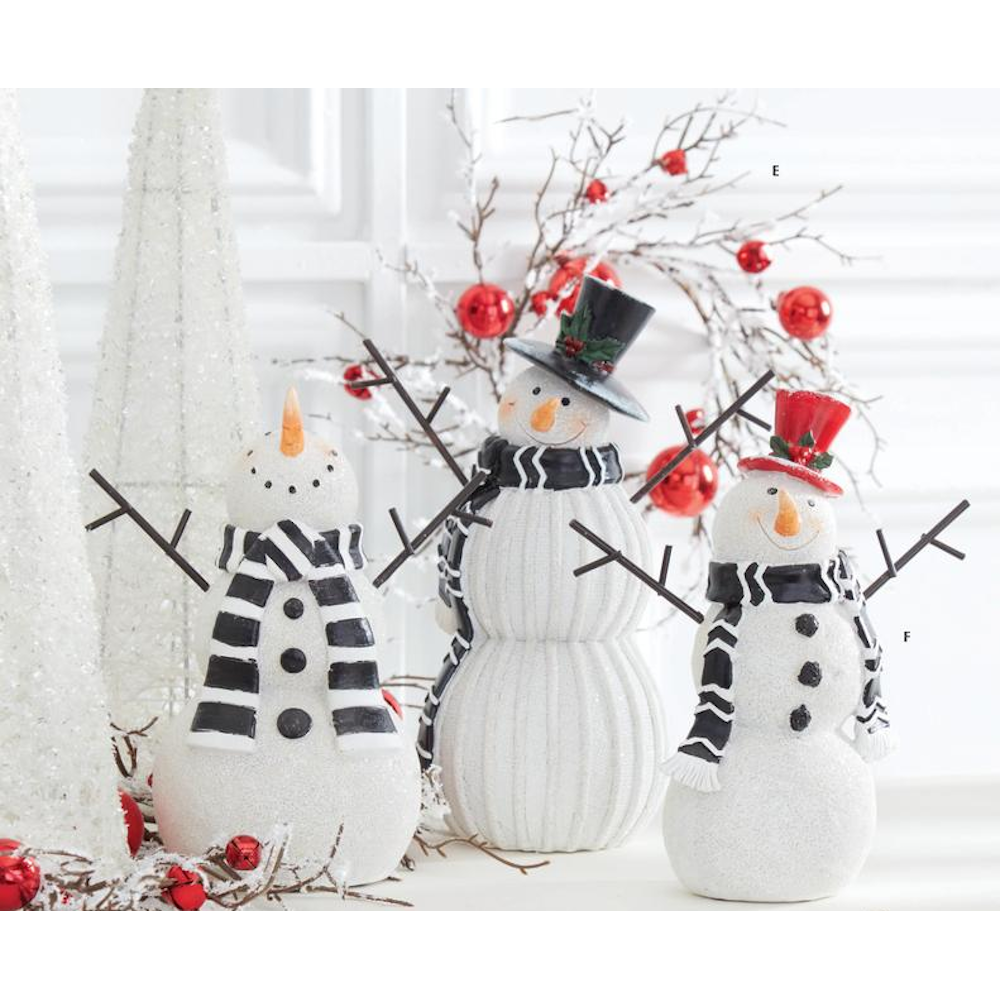 Three resin snowman figurines displayed with white glittering trees and festive red berry garlands.