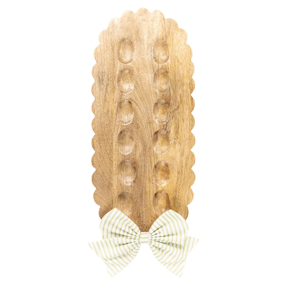 Reversible scalloped wooden bow holder board with light green striped fabric bow.