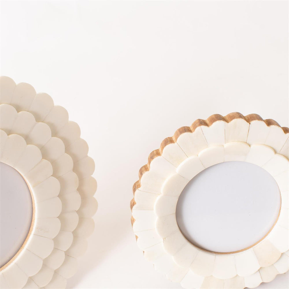 Round white scalloped bone photo frames featuring a layered petal design and natural wood edges on a white background.