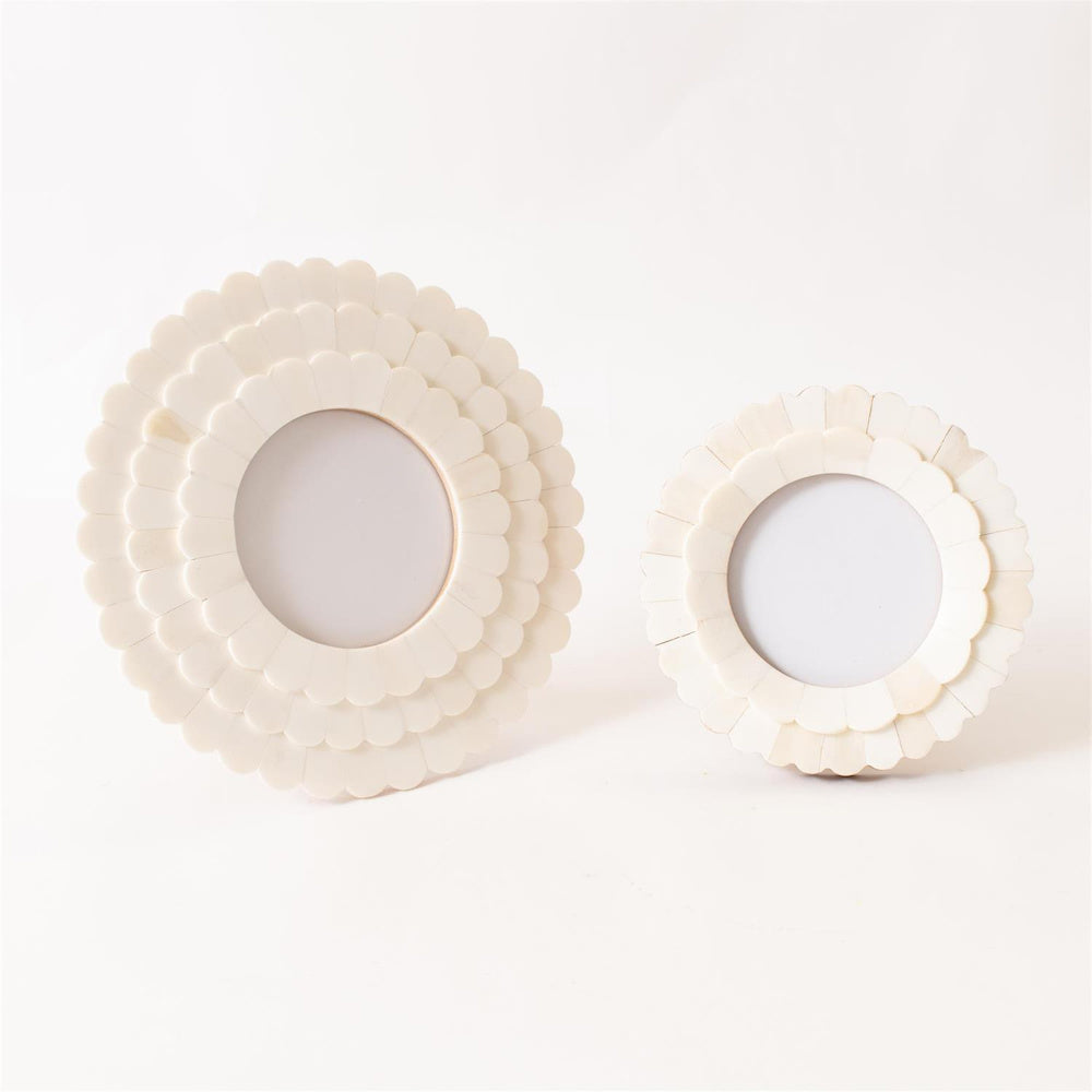 Two round cream scalloped bone inlay picture frames in small and large sizes on a white background.