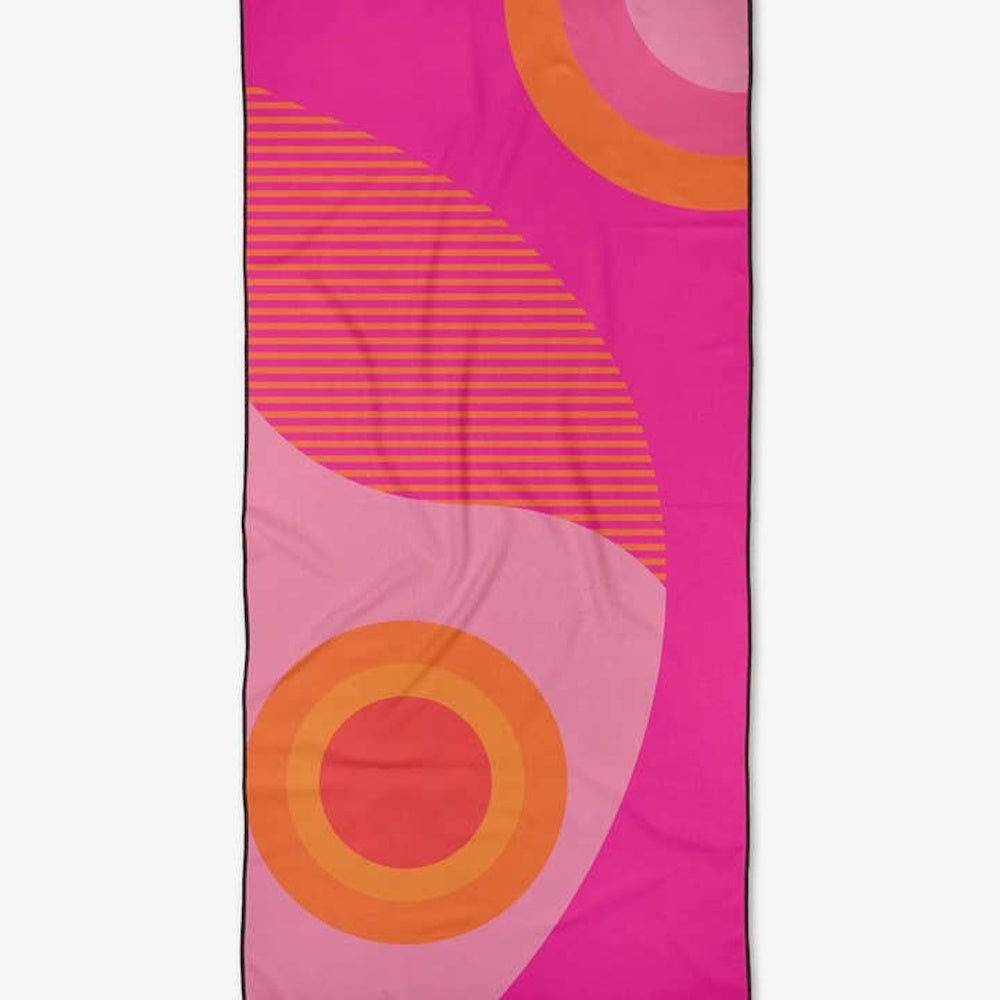 Brightly colored beach towel featuring hot pink, light pink, and orange geometric shapes and stripes.