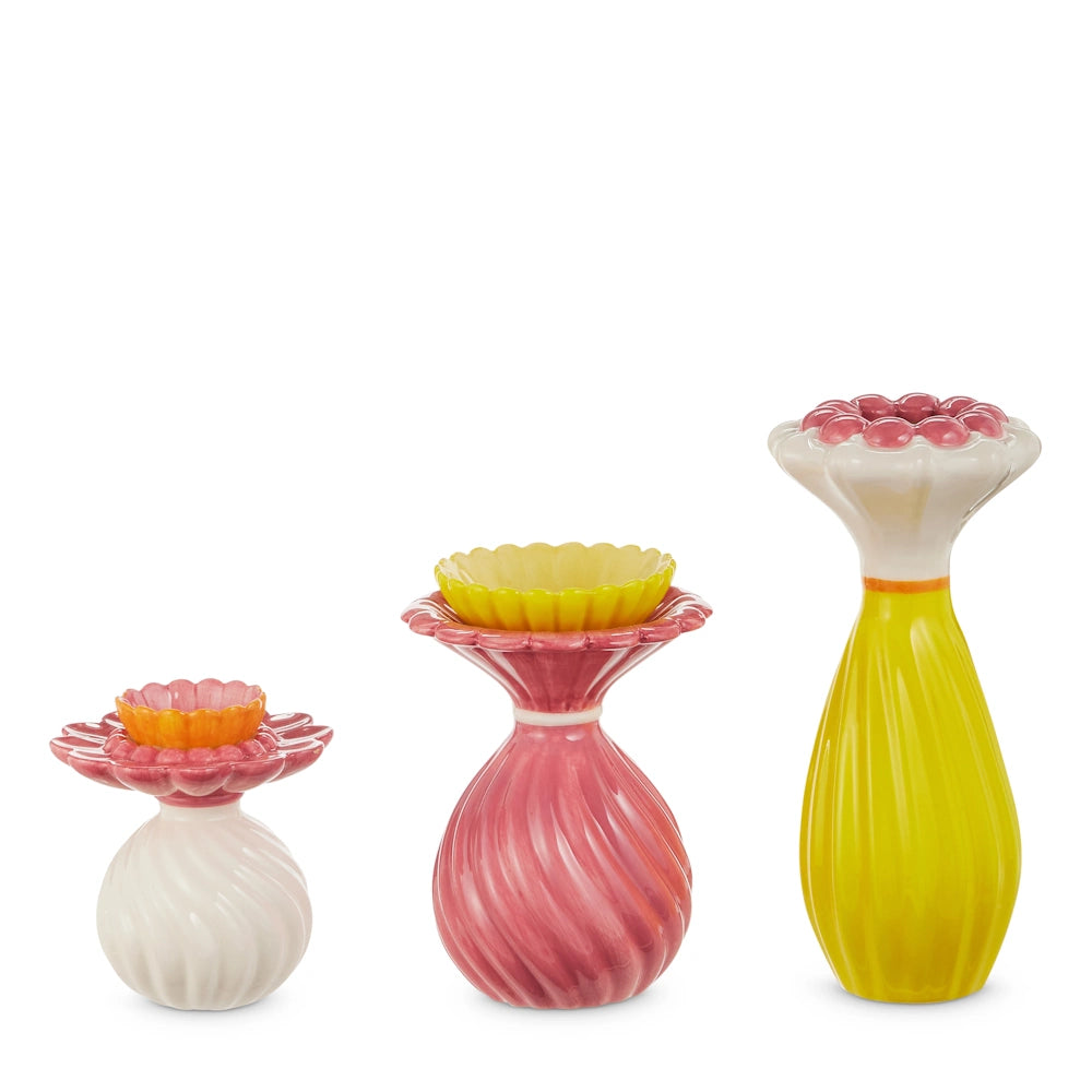 Three colorful ceramic ruffled whimsy bud vases in white, pink, and yellow with flower-shaped tops on a white background.