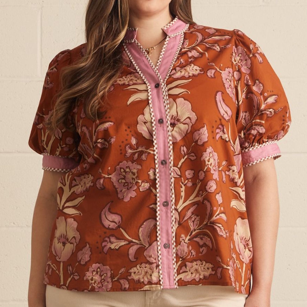 Rust floral print top with pink flowers, short puff sleeves, and a pink button placket.