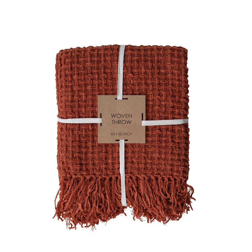 Folded rust-orange waffle-weave throw blanket tied with a ribbon and product label.