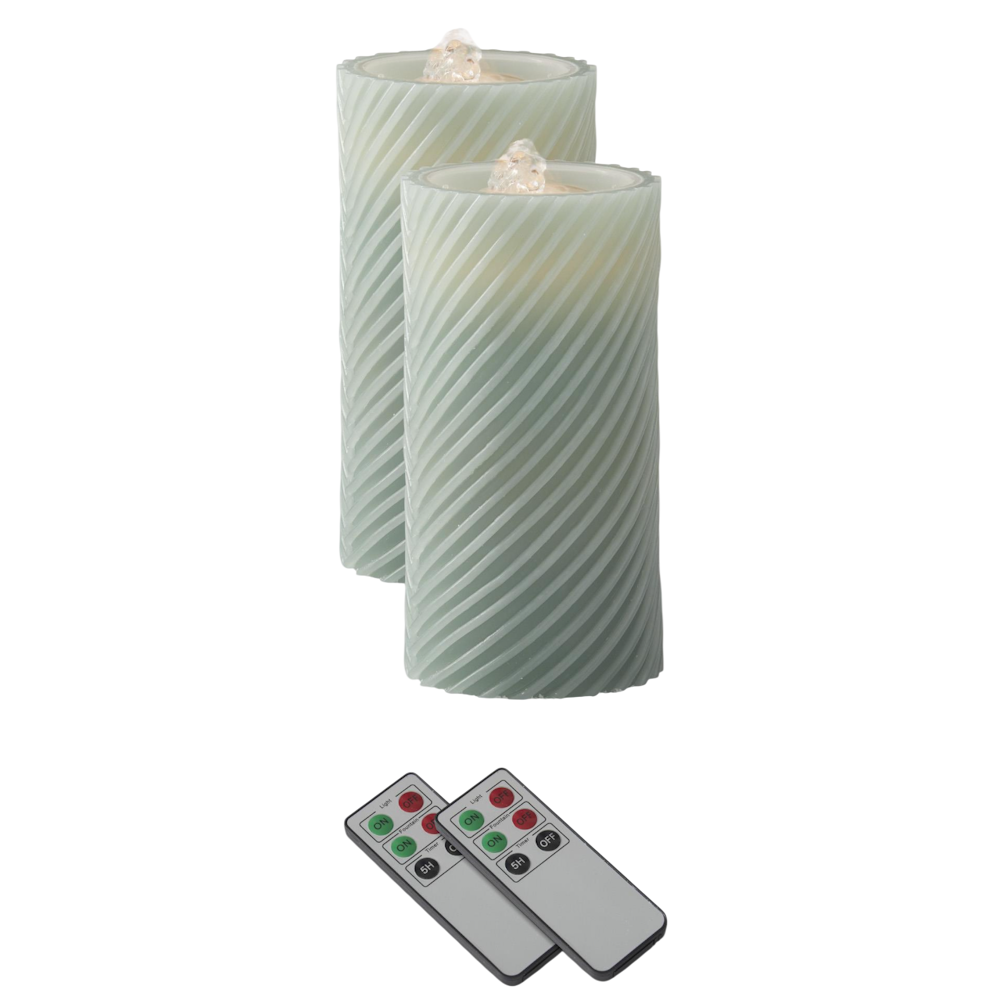 Two sage green spiral LED wax pillar water candles with flame-shaped tops and two remote controls on a white background.