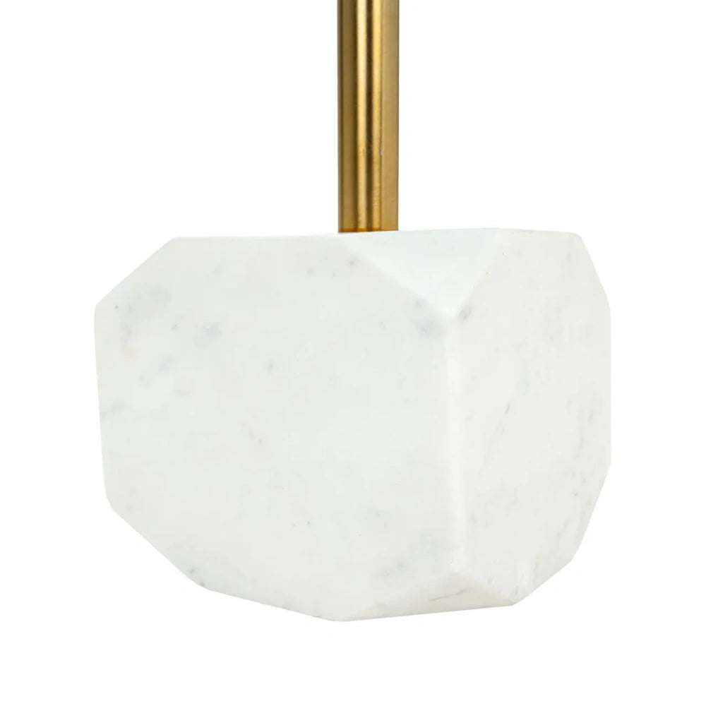 A faceted white marble base supporting a slender gold metal rod on a white background.