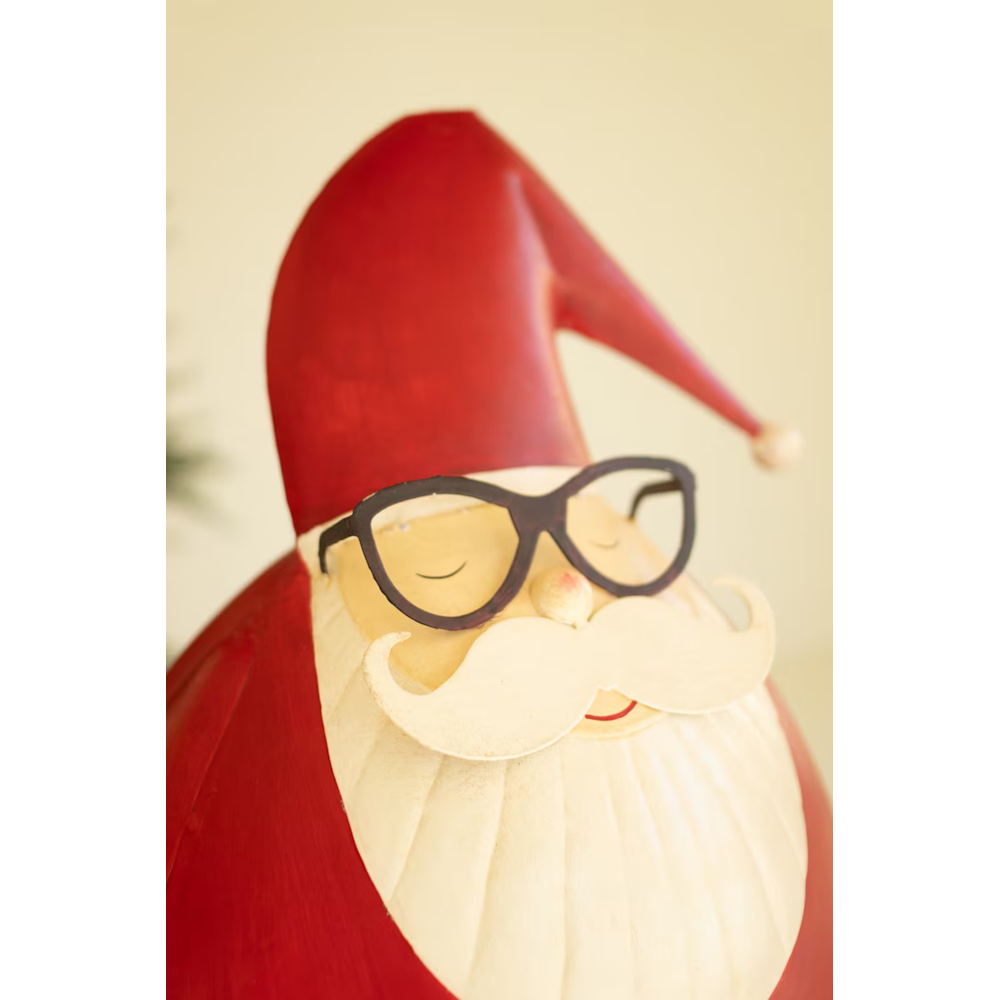 Close-up of a painted metal Santa sculpture highlighting his black spectacles and white beard.